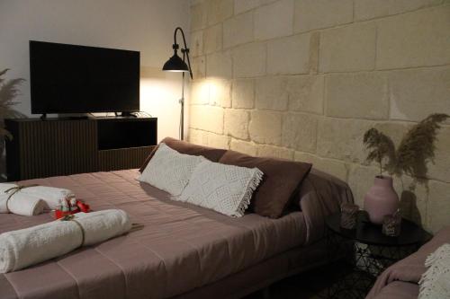 塔兰托BETÌ的一间卧室配有一张床,墙上配有电视