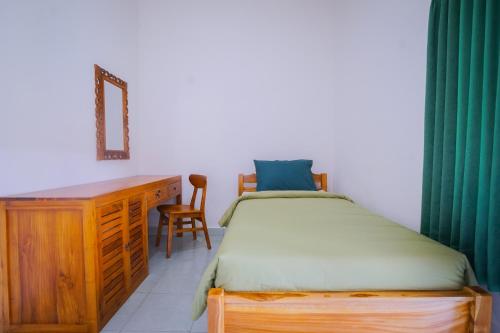 库塔Kos Bulan Bali的一间卧室配有一张床、一张桌子和一把椅子