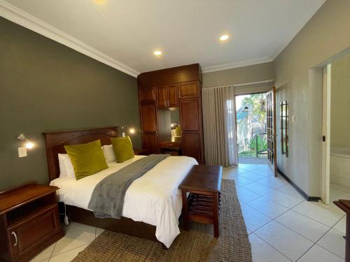 莱迪史密斯Farquhar Lodge的一间卧室配有一张带绿色枕头的大床