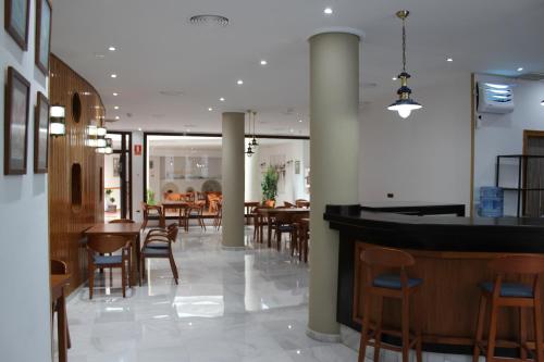 卡斯蒂列哈德拉库埃斯塔HOTEL HACIENDA SANTA BARBARA的一间带桌椅的餐厅和一间酒吧