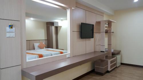 坤敬Kaen Nakorn Hotel的一间卧室配有一张床和一台电视
