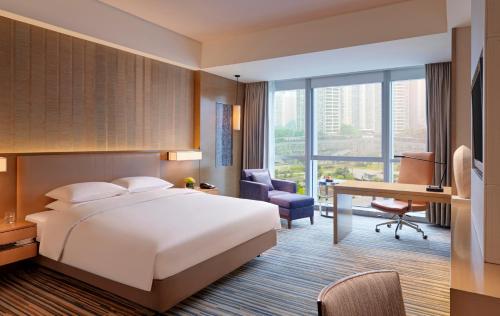 重庆重庆富力凯悦酒店的配有一张床和一张书桌的酒店客房