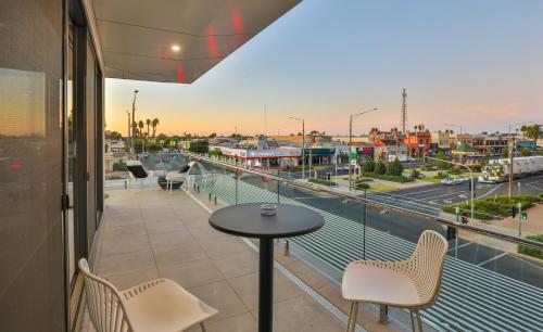 米尔迪拉Indulge Apartments - City View Penthouses的市景阳台配有桌椅。