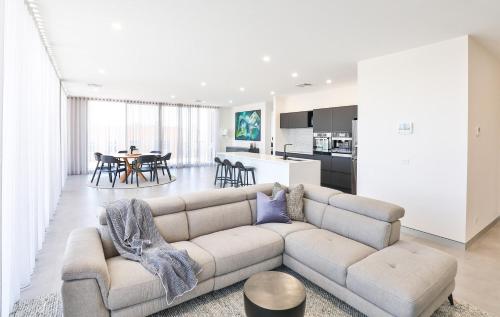 米尔迪拉Indulge Apartments - City View Penthouses的带沙发的客厅和厨房