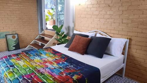 甲米镇Bann Kam B&B的一间卧室,床上有五颜六色的被子