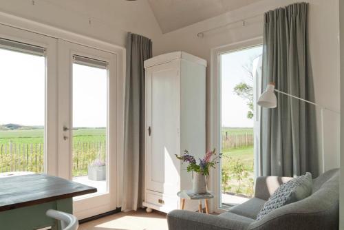 栋堡Vakantieverblijf de Trommel的带沙发、桌子和窗户的客厅