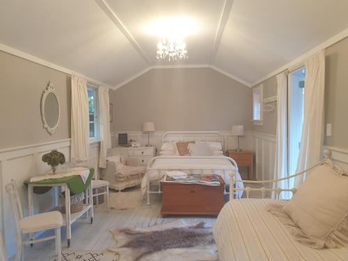 莫图伊卡Cabins on Tudor bed & breakfast的一间卧室配有两张床、一张沙发和一张桌子
