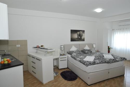 尼克希奇Apartment Jovana Nikšić的白色卧室设有床铺和水槽