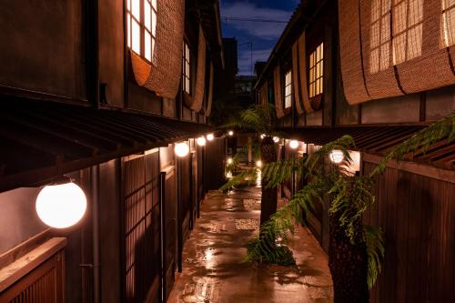 京都Rinn Shiki Juraku的建筑物一侧的一条有灯光的小巷