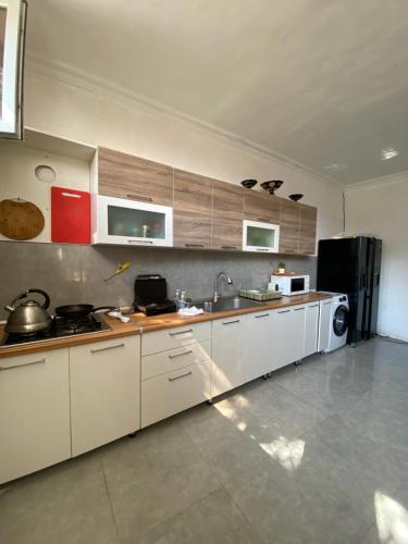 巴库CHEMPION HOSTEL BAKU的厨房配有白色橱柜和黑色冰箱。