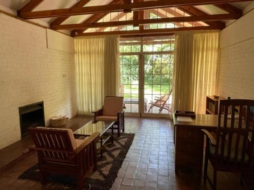 哈拉雷Weaver Cottages的客厅配有桌椅和壁炉