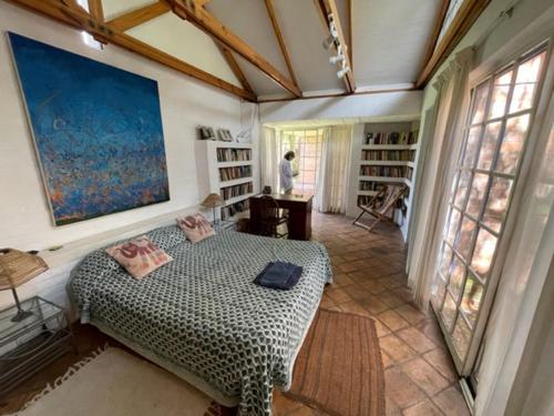 哈拉雷Weaver Cottages的一间带一张大床的卧室,位于带窗户的房间内