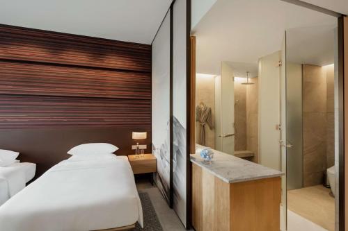 哥打京那巴鲁Hyatt Centric Kota Kinabalu的一间卧室设有一张床和一个步入式淋浴间。