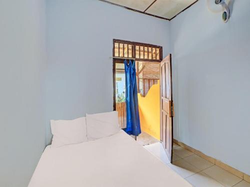 CupelSPOT ON 92404 Pondok Ai的卧室配有白色的床和开放式门。