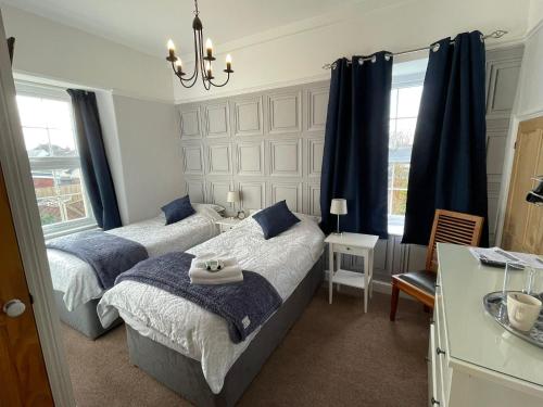 布朗顿The Brookfield的一间卧室配有两张床和吊灯。