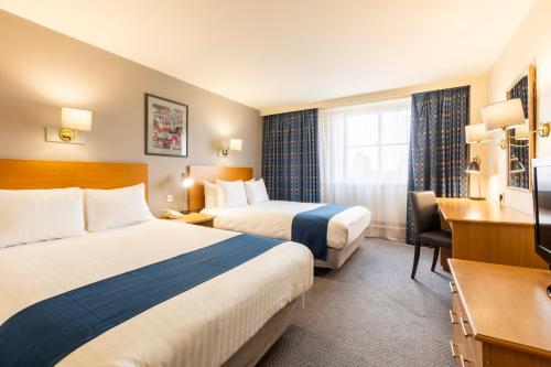 萨顿伦敦萨顿假日酒店的酒店客房配有两张床和一张书桌