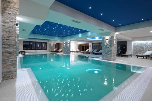 科查尼Magnolija Resort Ponikva的蓝色天花板房子内的游泳池