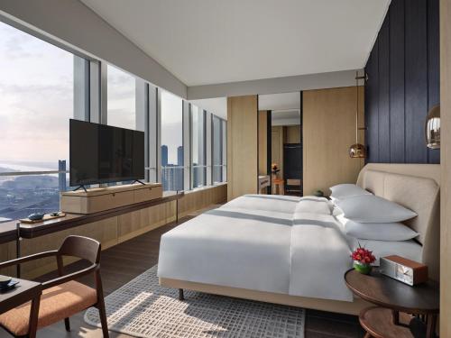 南京南京河西安达仕酒店的卧室配有一张白色大床和电视。