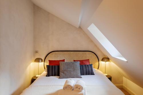 雷恩La Tourelle & l'Honoré - 2 appartements dans le Centre historique de Rennes的一间卧室配有一张床,上面有两条毛巾