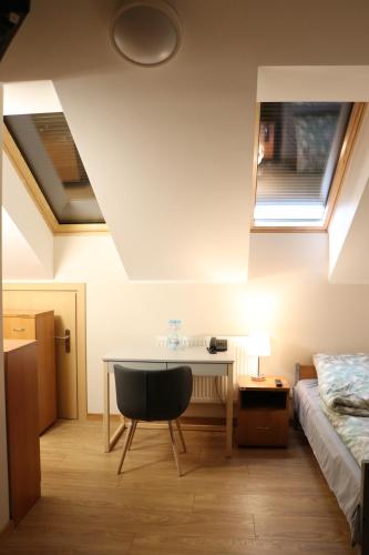 普热梅希尔Dom Studenta PANS - Akademik, Hostel的一间卧室配有书桌、床和窗户。