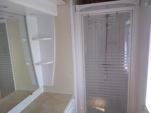 普卢盖尔诺Mobilhome Plouguerneau的白色衣柜,带玻璃门和镜子