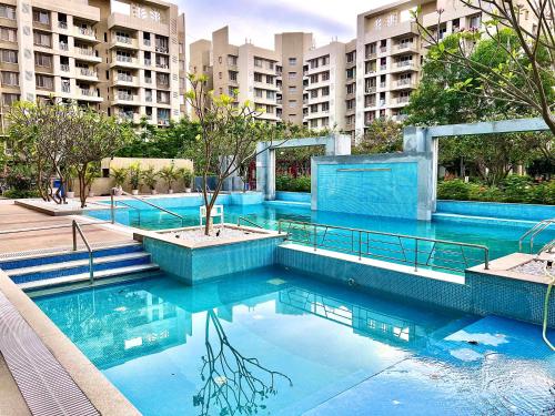 那格浦尔2BHK luxurious beautiful flat near IIM AIIMS的大楼前的蓝色海水游泳池