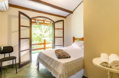 彼得罗波利斯Sítio Borges的一间卧室配有一张床、一张桌子和一个窗户。