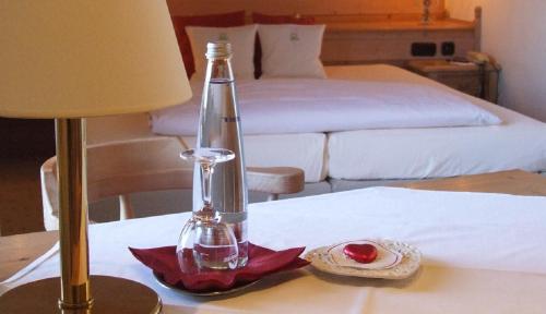 Iffeldorf兰德加斯托奥斯特希酒店的桌子上放着一盏灯和一瓶