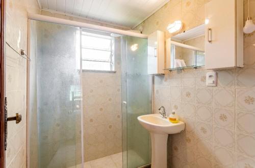 彼得罗波利斯Sítio Borges的一间带玻璃淋浴和水槽的浴室