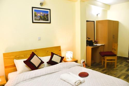 帕坦Tanani Newa Home (Mt. Gouri)的一间卧室配有一张大床和一张红色椅子