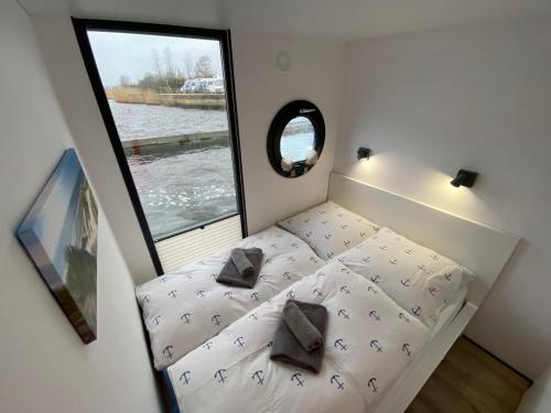 石勒苏益格Hausboot Claudia Schleswig的一个小房间的小床,设有窗户
