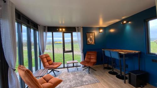 弗拉讷克Vakantiehuis Maria Louise的客厅拥有蓝色的墙壁和桌椅