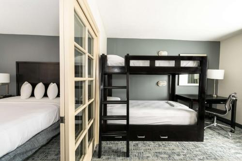 圣地亚哥Best Western Inn & Suites San Diego Zoo -SeaWorld Area的一间卧室配有两张双层床和一张书桌