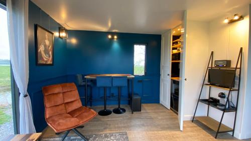 弗拉讷克Vakantiehuis Maria Louise的一间设有一张桌子和一把椅子的蓝色墙壁客房