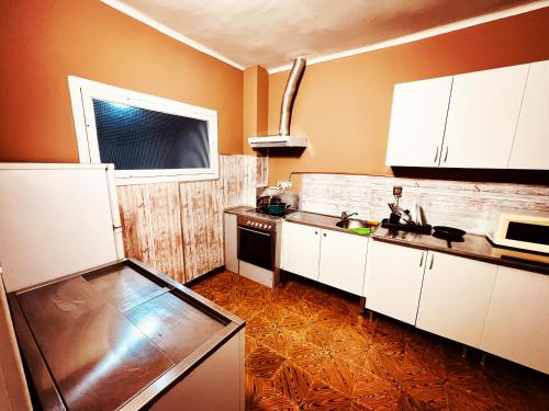 奥波里尼奥Alojamiento Camino Portugues的厨房配有白色橱柜、水槽和窗户。