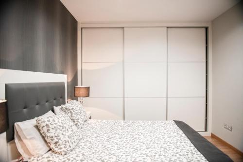 钱塔达Apartamento Cuatro Caminos的一间卧室配有一张带白色橱柜的大床