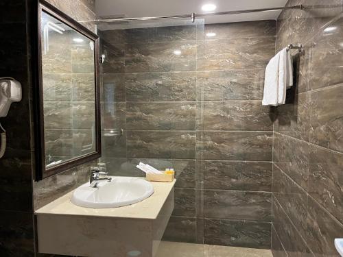 胡志明市Phung Long Hotel的一间带水槽和瓷砖墙的浴室