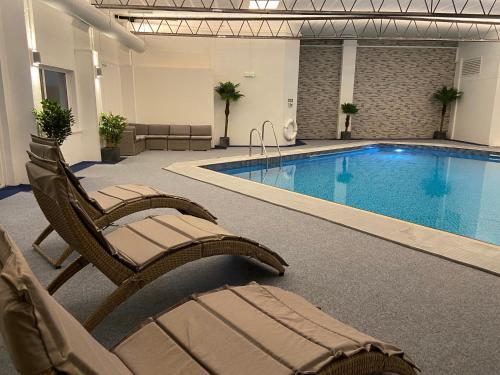 纽基彭迪尔酒店的酒店游泳池设有椅子和游泳池