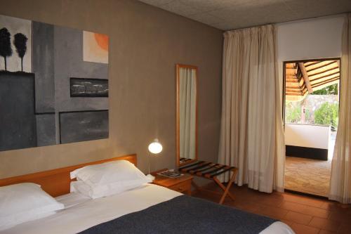 奥马鲁鲁Central Hotel Omaruru的一间卧室配有一张床、一张桌子和一个窗户。