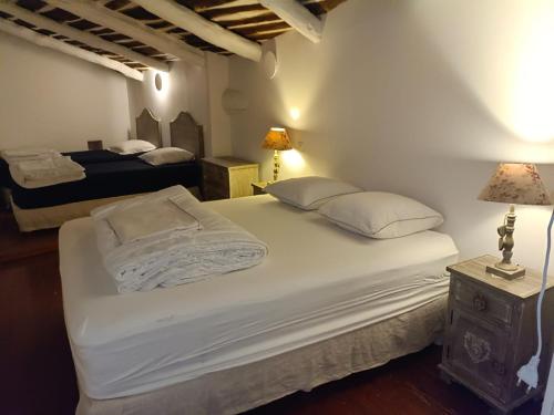 Fressacgrand gîte de charme en Cévennes的一间卧室配有两张带白色床单和枕头的床。