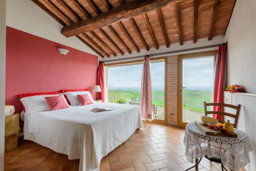 阿夏诺Agriturismo Le Crete - Appartamenti的一间卧室设有一张床和一个大窗户