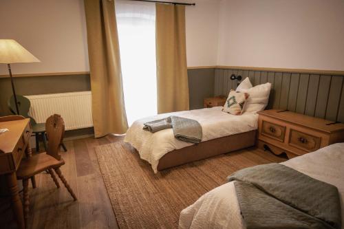 阿尔特多夫Kastanienhof Pfettrach的一间卧室设有两张床、一张桌子和一个窗口。