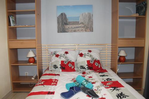 Saint-Martin-lez-TatinghemChambres d'Hôtes Les Mésanges的一间卧室配有一张带红白色床单和枕头的床。