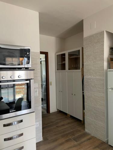 Tenna Lake Apartment Ischia Red的厨房配有炉灶和微波炉。