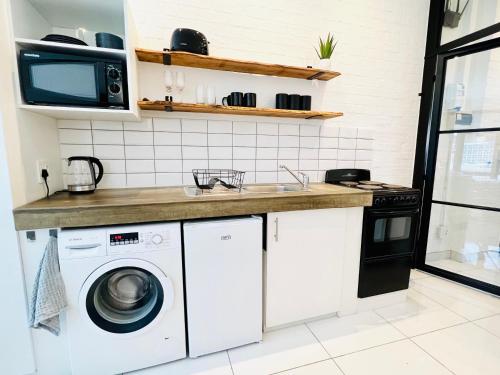 约翰内斯堡Industrial CHIC Apartment 113的厨房配有洗衣机和水槽