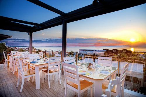 斯卡拉卡里拉奇斯Anny Residences & Suites的一张带白色椅子的桌子,享有海景