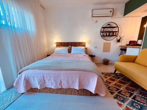 埃拉特Eilat charming & cozy Studio的一间卧室配有一张大床和一张黄色的沙发