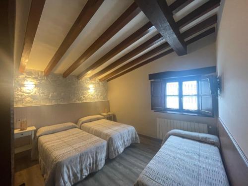 桑提亚纳德玛索拉纳旅馆的一间卧室设有两张床和窗户。