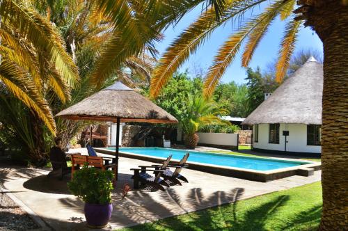 奥马鲁鲁Central Hotel Omaruru的一个带游泳池和棕榈树的度假村