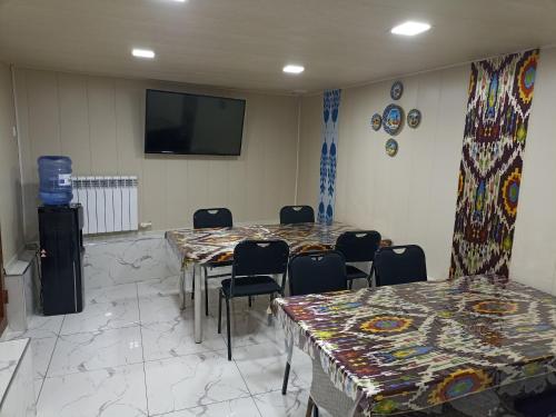撒马尔罕OQSAROY SAMARKAND Guest House的一间会议室,配有桌椅和平面电视